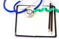 Stethoscope,pencil and measuring tape on notebook on a white background