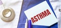 Stethoscope, pens and note with text ASTHMA on the doctor uniform Royalty Free Stock Photo