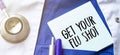 Stethoscope, pens and note with text get your flu shot on the doctor uniform Royalty Free Stock Photo