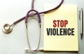 Stethoscope, pens and note with text STOP VIOLENCE on the doctor uniform Royalty Free Stock Photo
