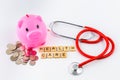 Stethoscope with piles of coins, red heart, piggy bank, saving f Royalty Free Stock Photo