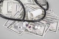 Stethoscope and pills on American Dollars Royalty Free Stock Photo
