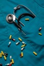 Stethoscope and pills on blue medical coat background. Medicine and Healthcare Concept Royalty Free Stock Photo