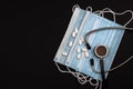 Stethoscope, pills and mask on a black background. Medical theme. Covid or coronavirus concept, copy space Royalty Free Stock Photo