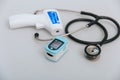 Stethoscope, pulse oximeter and thermometer gun on white background. Phonendoscope. Infrared isometric thermometer gun