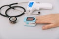 Stethoscope, pulse oximeter and thermometer gun on white background. Phonendoscope. Infrared isometric thermometer gun