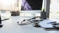 Stethoscope putting on doctor working desk surrounded by clipboard, thermometer, pen and coffee . Royalty Free Stock Photo