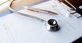 Stethoscope and record information paper folder with pen on Laptop, smart phone at medicine doctor work, on blur patient in Royalty Free Stock Photo