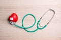 Stethoscope and red heart with adhesive plasters on wooden background, top view. Cardiology Royalty Free Stock Photo