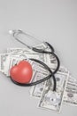 Stethoscope and red heart on American Dollars Royalty Free Stock Photo