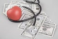 Stethoscope and red heart on American Dollars Royalty Free Stock Photo