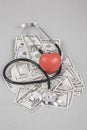 Stethoscope and red heart on American Dollars Royalty Free Stock Photo
