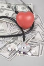 Stethoscope and red heart on American Dollars Royalty Free Stock Photo