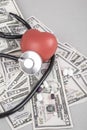 Stethoscope and red heart on American Dollars Royalty Free Stock Photo