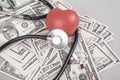 Stethoscope and red heart on American Dollars Royalty Free Stock Photo