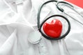 Stethoscope with red heart and doctor's coat, closeup. Health concept Royalty Free Stock Photo