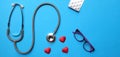Stethoscope red heart shape and glasses, Magnifying glass medicine panel , on blue paper background