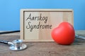 Stethoscope, red heart shape and wooden board written with text Aarskog Syndrome