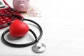 Stethoscope and red heart on white wooden surface. Health insurance concept Royalty Free Stock Photo