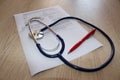 Stethoscope and rescription form lying on table with and pen