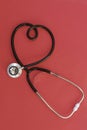 Stethoscope in the shape of heart on red background Royalty Free Stock Photo