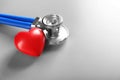 Stethoscope and small red heart on table Royalty Free Stock Photo