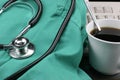 Stethoscope with smock, coffee & keyboard. Royalty Free Stock Photo