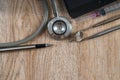 Stethoscope with syringe, pen, tablet and dental tools on wooden table Royalty Free Stock Photo
