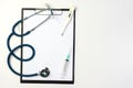 Stethoscope, syringe and thermometer on clipboard with blank paper Royalty Free Stock Photo