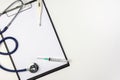 Stethoscope, syringe and thermometer on clipboard with blank paper Royalty Free Stock Photo