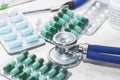 Stethoscope on the table, blurred capsules, medicines, medicine bottles and medical supplies Royalty Free Stock Photo