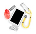 Stethoscope, tablet, pills and model of heart