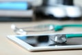 Stethoscope and tablet on table, closeup. Medical stuff