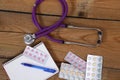 Stethoscope and tablets isolated on wooden background Royalty Free Stock Photo