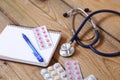 Stethoscope and tablets isolated on wooden background Royalty Free Stock Photo