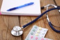 Stethoscope and tablets isolated on wooden background Royalty Free Stock Photo