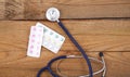 Stethoscope and tablets isolated on wooden background Royalty Free Stock Photo