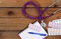 Stethoscope and tablets isolated on wooden background Royalty Free Stock Photo