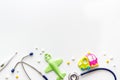 Stethoscope, toys and pills - baby flu and cold concept - on white background top view copy space