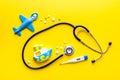 Stethoscope, toys and pills - baby flu and cold concept - on yellow background top view