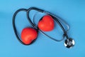 Stethoscope and two rubber hearts on a blue background with space for text. Royalty Free Stock Photo