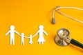 Stethoscope on yellow background with family paper health medical,red heart Royalty Free Stock Photo