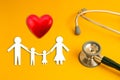 Stethoscope on yellow background with family paper health medical,red heart copy space Royalty Free Stock Photo
