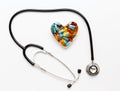 Stethoscope on white background with pills in shape of heart Royalty Free Stock Photo