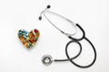 Stethoscope on white background with pills in shape of heart Royalty Free Stock Photo