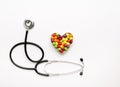 Stethoscope on white background with pills in shape of heart Royalty Free Stock Photo