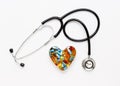 Stethoscope on white background with pills in shape of heart Royalty Free Stock Photo