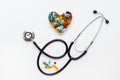 Stethoscope on white background with pills in shape of heart Royalty Free Stock Photo