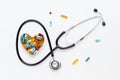 Stethoscope on white background with pills in shape of heart Royalty Free Stock Photo