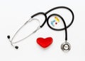 Stethoscope on white background with plush heart and pills Royalty Free Stock Photo